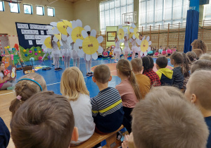 szkolne dzieci tańczą taniec z kwiatami